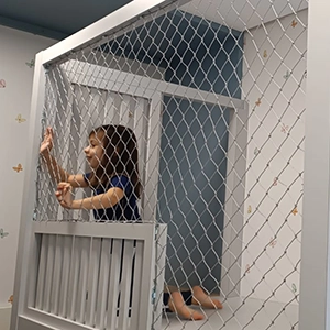 criança dentro da cama, protegida por rede de proteção