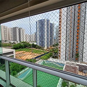 varanda com rede de proteção, com quadra e outros prédios, ao fundo