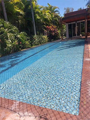 foto de uma piscina protegida com rede de proteção sobre ela, impedindo que alguém caia